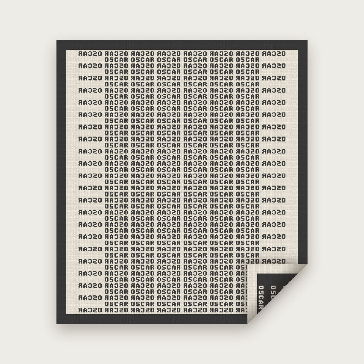 The Heir blanket in Charcoal and bone, laid flat with one corner folded back to show the reverse
