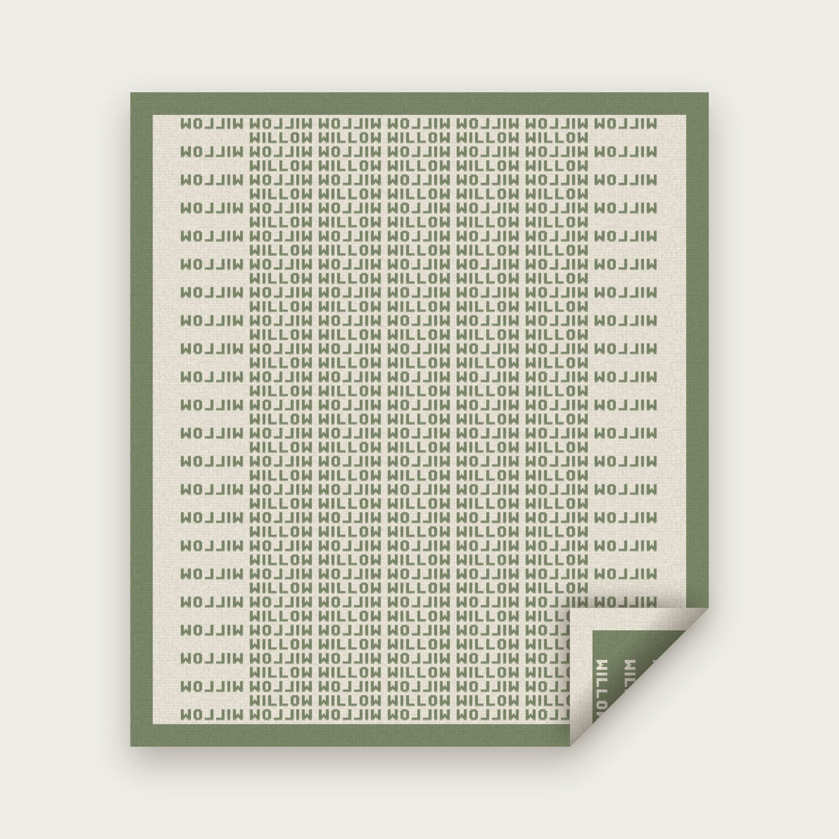 The Heir blanket in Sage and bone, laid flat with one corner folded back to show the reverse