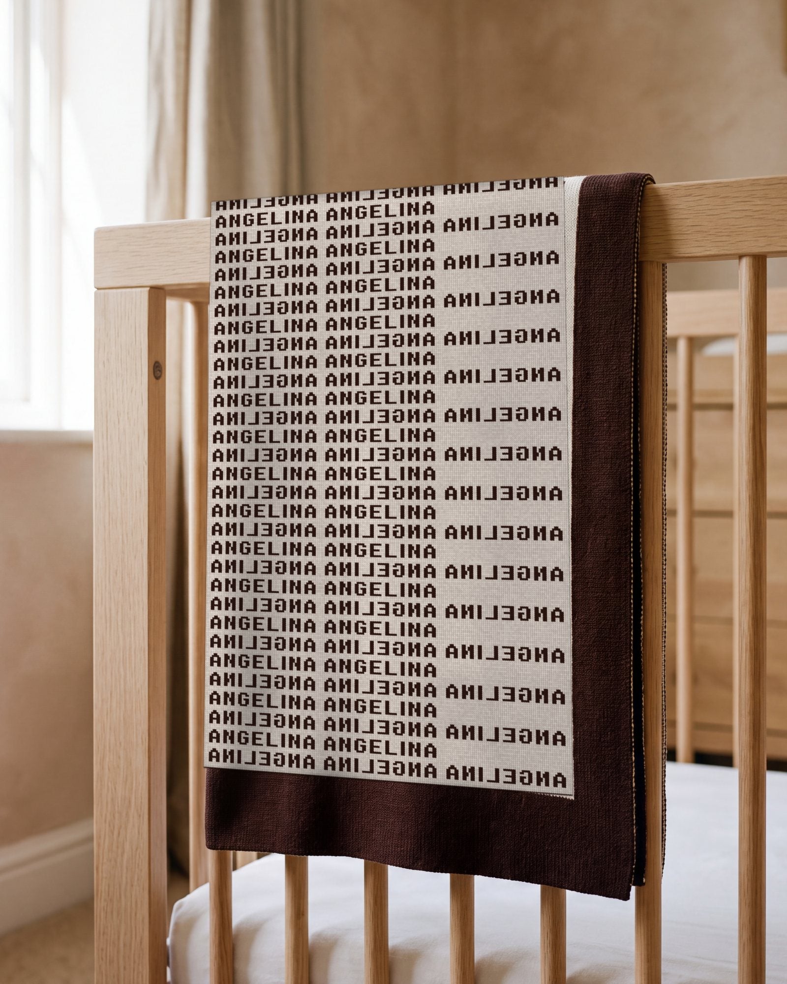 The Heir blanket for Angelina folded over the rail of an oak cot in a sunlit room