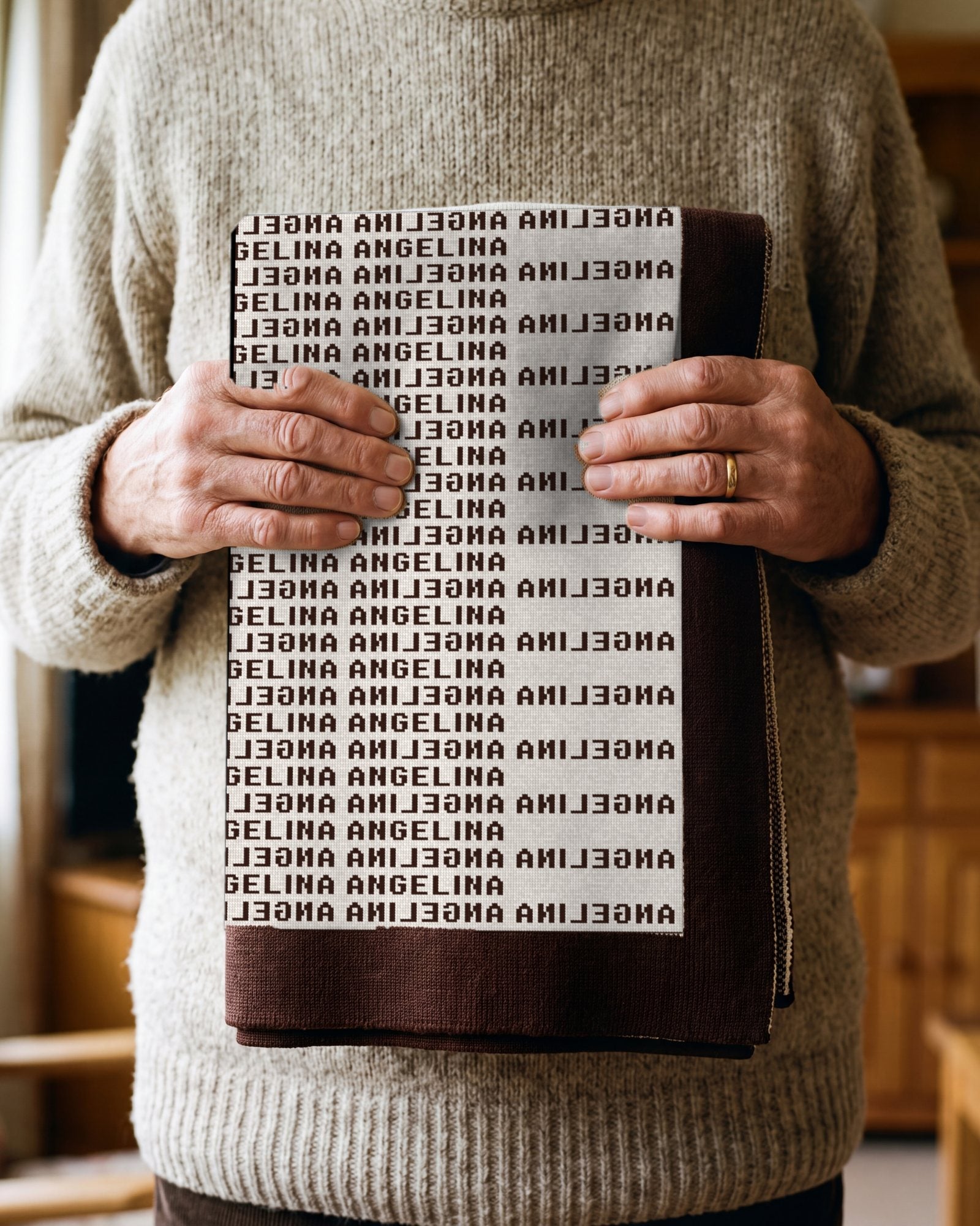 An older person's hands holding the folded blanket against a wool jumper